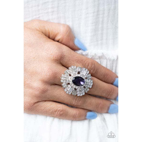 Paparazzi Iceberg Ahead – Purple Stretch Ring  A sparkly series of round and emerald-cut rhinestone petals flare out from a purple oval rhinestone center, creating a dramatically oversized centerpiece atop the finger. Features a stretchy band for a flexible fit.  Sold as one individual ring.