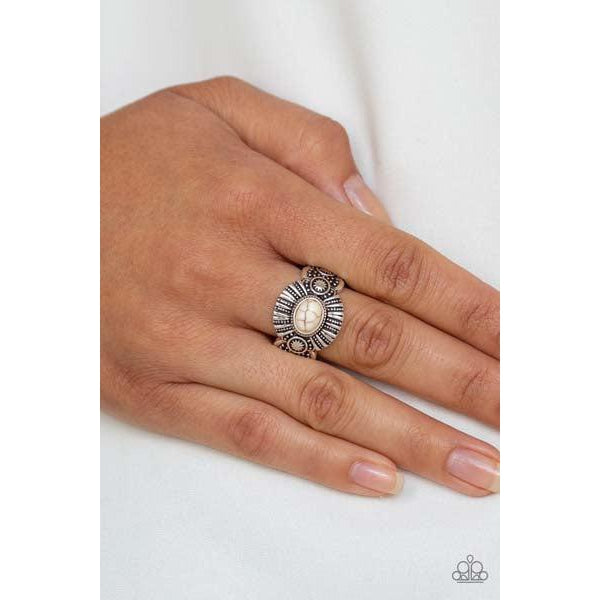 An oval white stone is pressed into the center of an ornate silver frame radiating with linear and sunburst patterns for a seasonal flair. Features a dainty stretchy band for a flexible fit.  Sold as one individual ring.